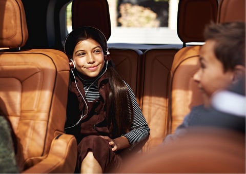 Two young people are shown comfortably seated in the second and third rows of a Lincoln Aviator® SUV