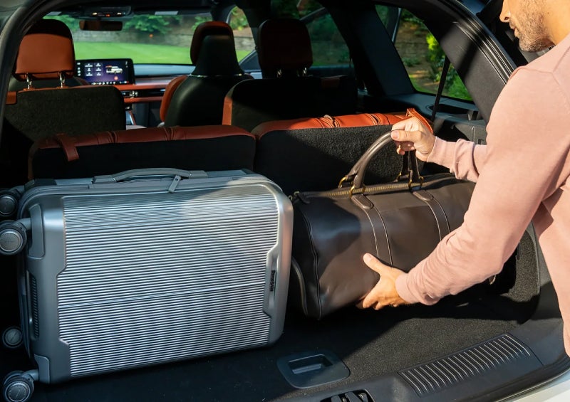 A man loads luggage into the rear of a 2026 Lincoln Aviator® SUV through the opened rear liftgate. | Lincoln North Miami in North Miami FL