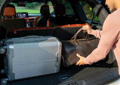 A man loads luggage into the rear of a 2026 Lincoln Aviator® SUV through the opened rear liftgate. | Lincoln North Miami in North Miami FL