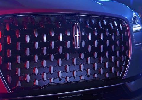 The grille of a 2025 Lincoln Corsair® SUV reflects neon light at night. | Lincoln North Miami in North Miami FL