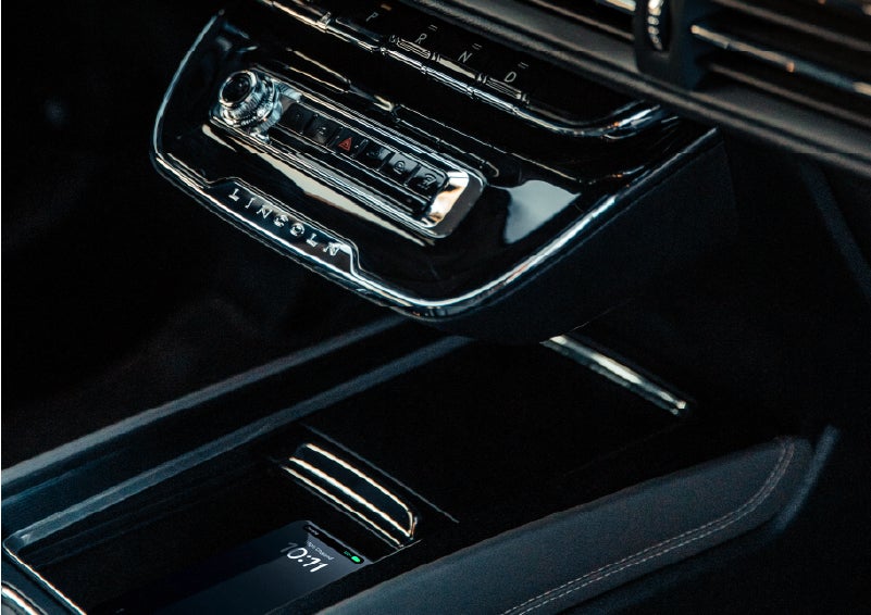 A smartphone rests on the available wireless charging pad in the front center console cubby. | Lincoln North Miami in North Miami FL